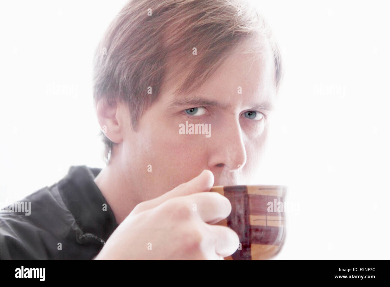 L'uomo beve il tè. Ritratto dell'uomo. Egli detiene una coppa in ceramica da cui le bevande calde drink in mano. Foto Stock