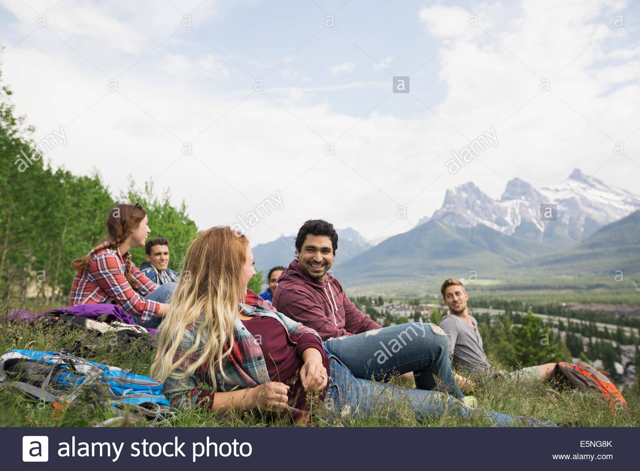 Amici rilassante in erba vicino alle montagne Foto Stock