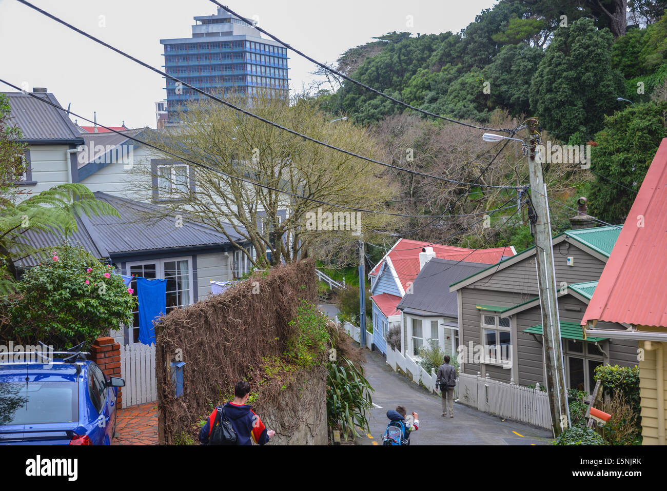 Ripido residenziale posizione di alloggiamento a Wellington in Nuova Zelanda con l uomo e bambino a piedi giù per la strada ripida. Foto Stock