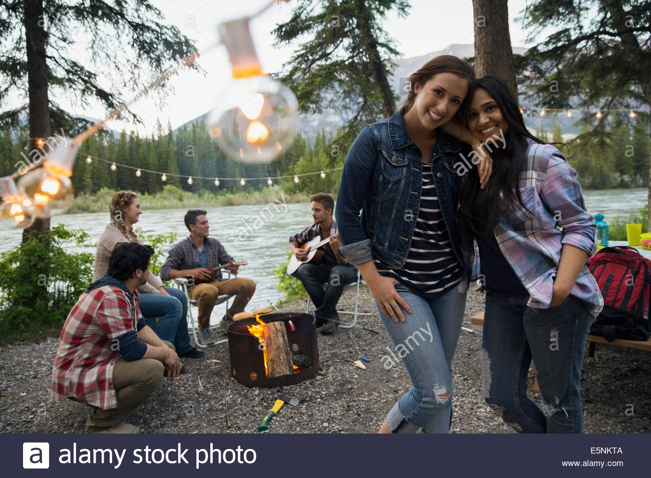 Amici appendere fuori intorno al falò in campeggio Foto Stock