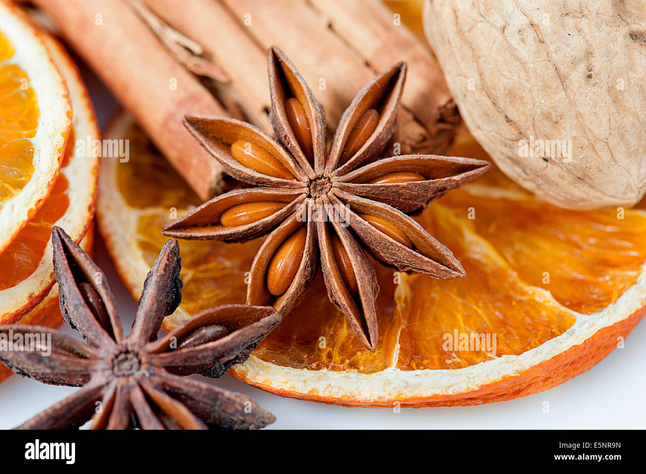 Fette di arancia essiccate con bastoncini di cannella, anice stelle e noci Foto Stock