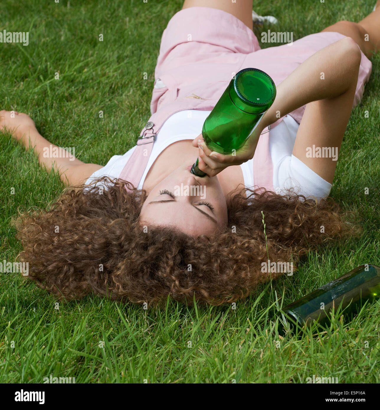 Teenage problema bere bevande ragazza da una bottiglia di birra Foto Stock