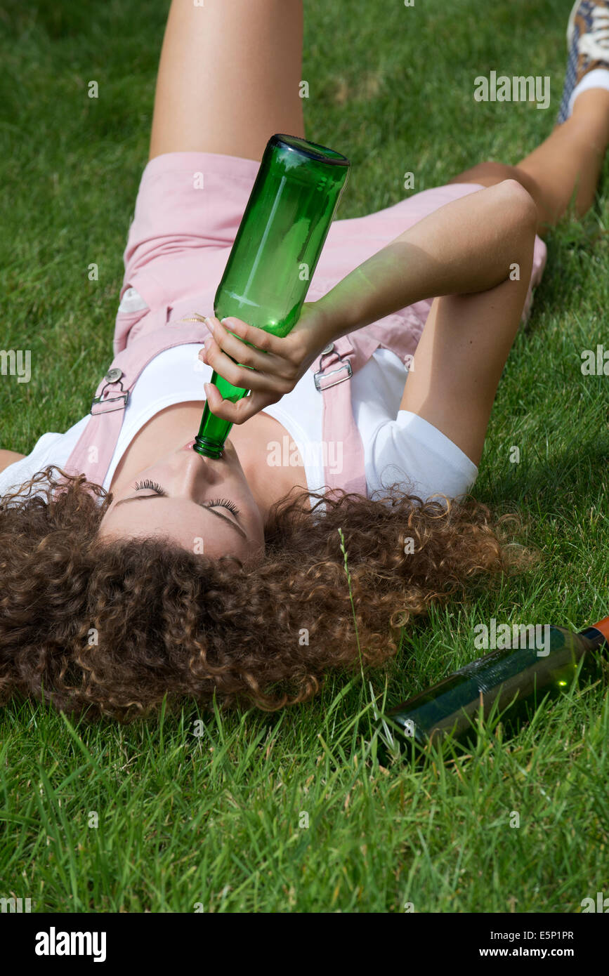 Teenage problema bere bevande ragazza da una bottiglia di birra Foto Stock