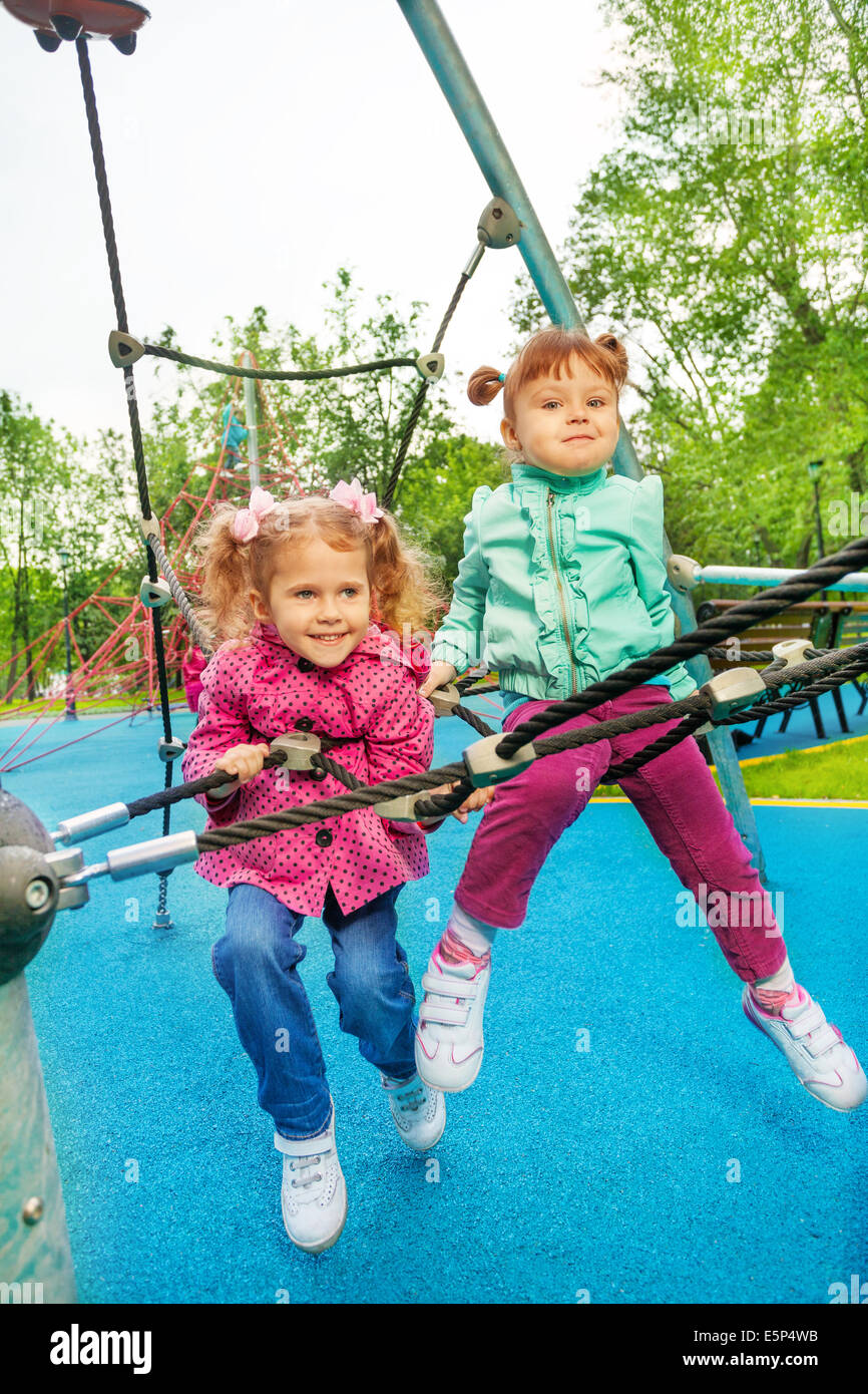 Due ragazze divertente insieme sulla griglia del parco giochi Foto Stock