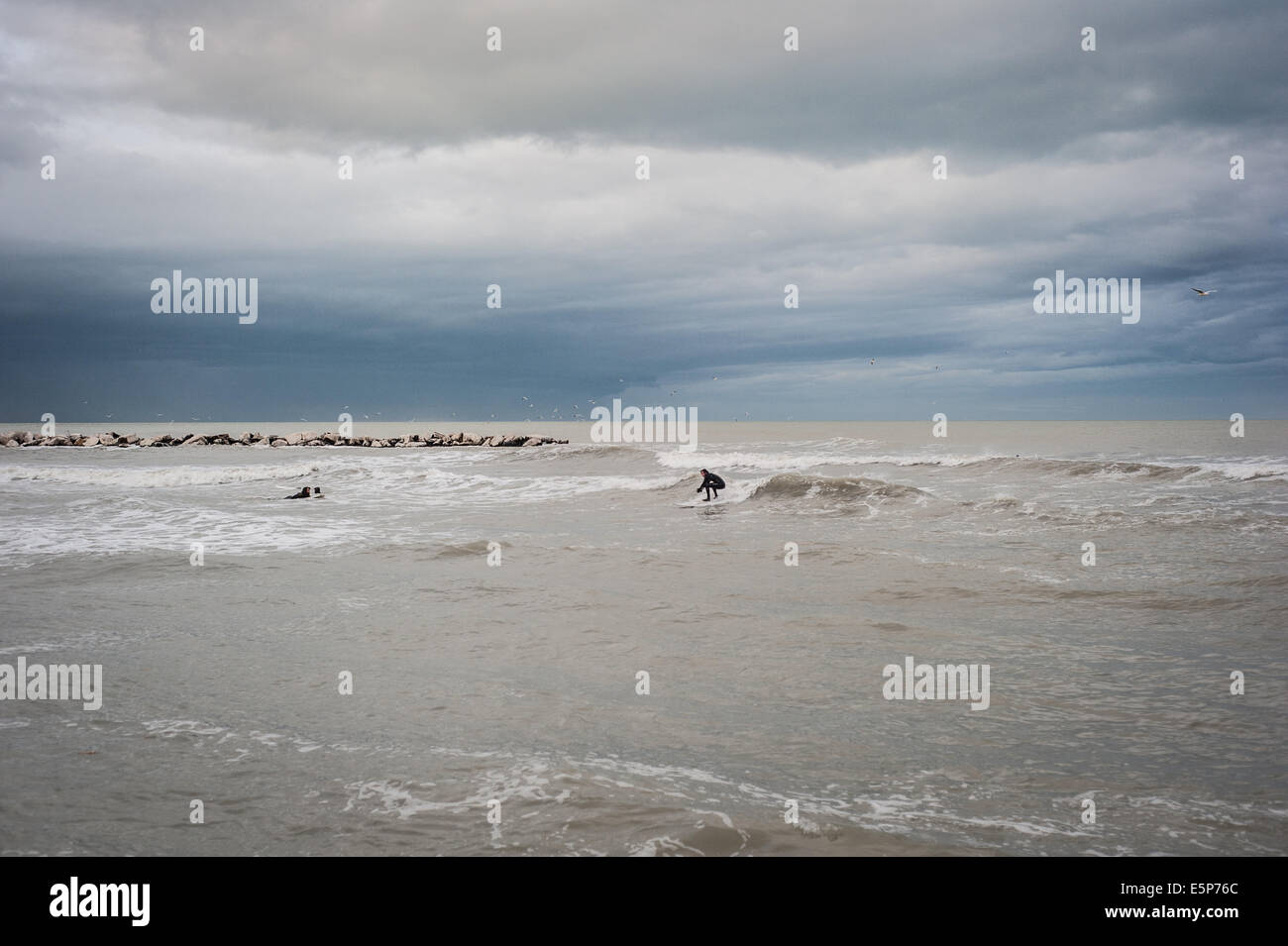 Surfer in mare su di una giornata invernale a Rimini Foto Stock