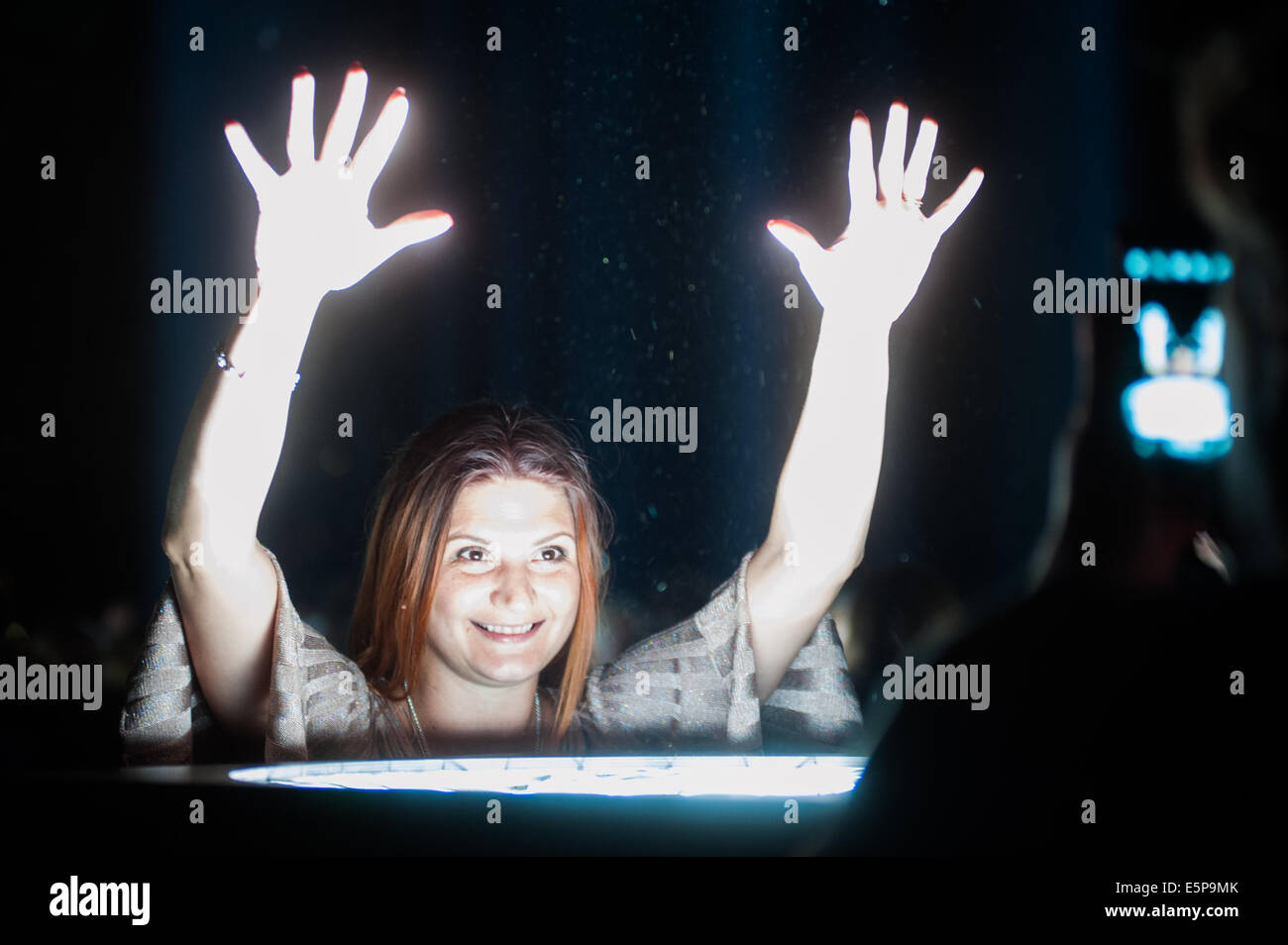 Londra, Regno Unito. 4 Ago, 2014. Una donna interagisce con le luci fuori Londra gli spettri di installazione da Ryoji Ikeda per il centenario di WW1. Credito: Piero Cruciatti/Alamy Live News Foto Stock