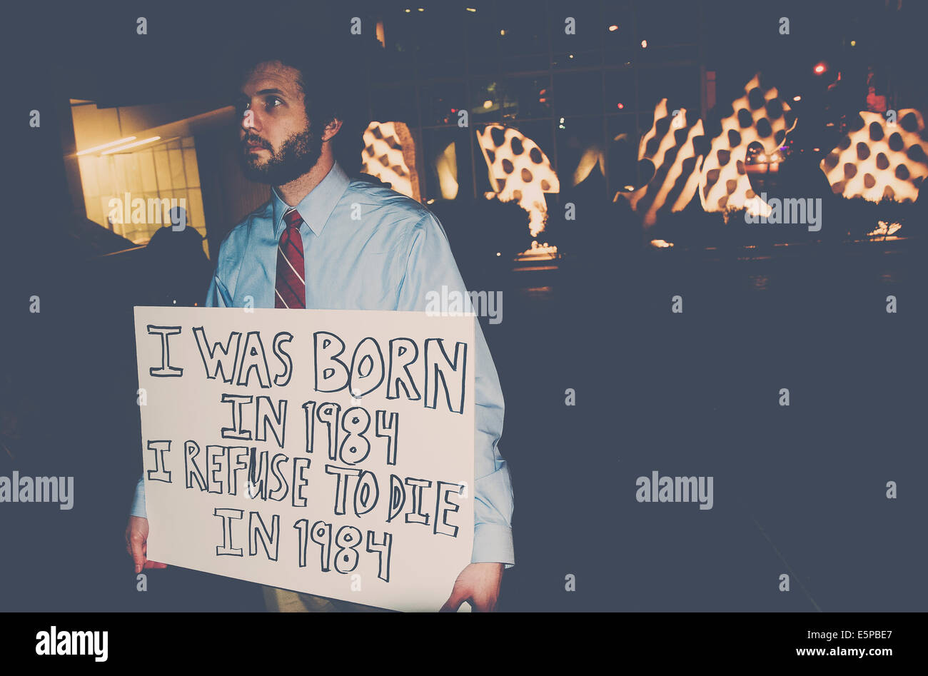 Un uomo tenendo un cartello durante una protesta contro il governo di massa di sorveglianza. "Sono nato nel 1984 mi rifiuto di morire nel 1984' Foto Stock