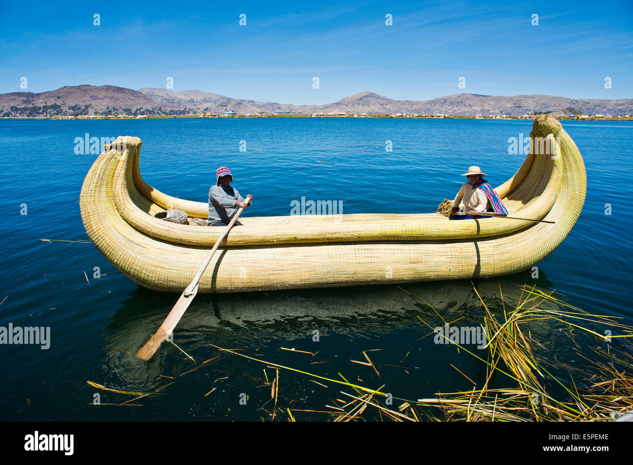 Due locali in una tradizionale barca a remi di Totora pettine sul lago Titicaca, Perù Foto Stock