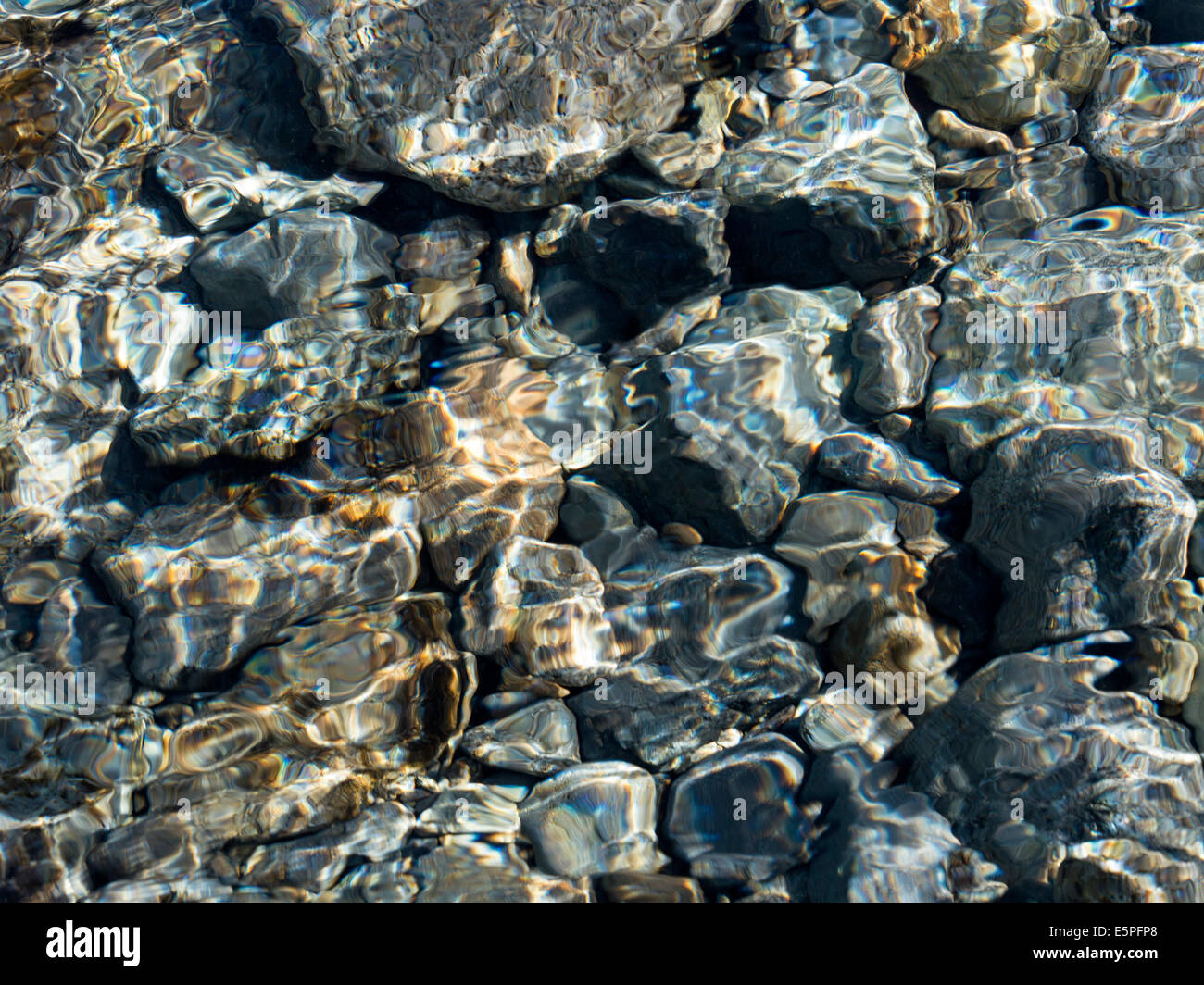 Abstract coloratissimi fondali bassi di increspature soleggiato sopra i ciottoli nel letto di ruscello, Scotland, Regno Unito Foto Stock