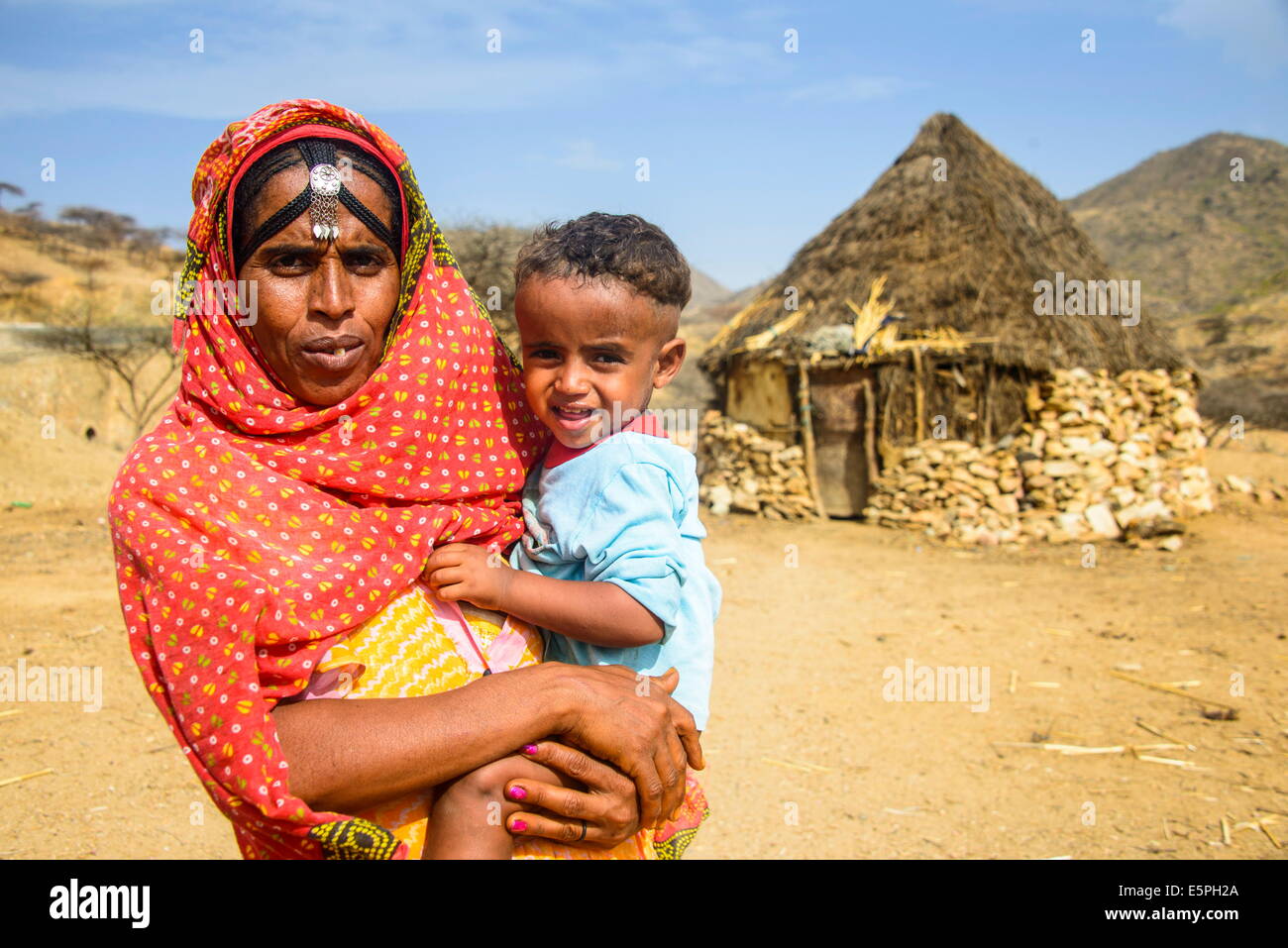 Madre con suo figlio nella parte anteriore di una capanna tradizionale nelle Highlands di Eritrea, Africa Foto Stock