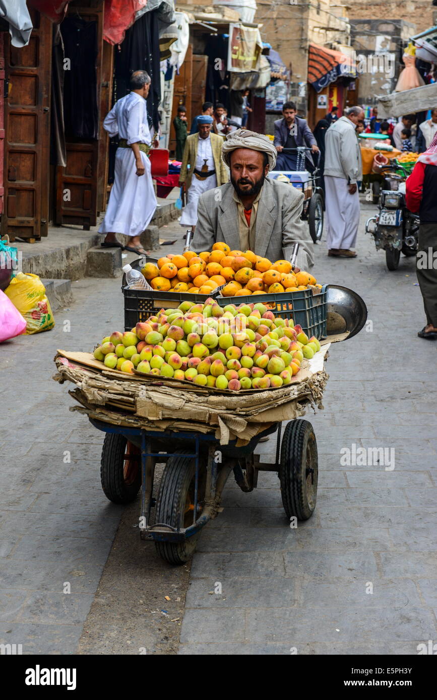 L'uomo per la vendita di frutta nella Città Vecchia, sito Patrimonio Mondiale dell'UNESCO, Sanaa, Yemen, Medio Oriente Foto Stock