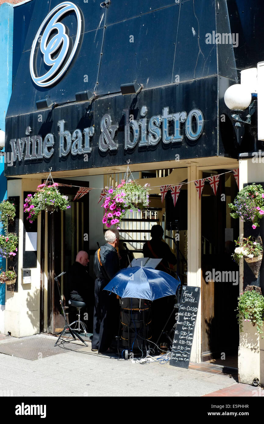 Gruppo di musicisti suonano ad un pubblico in un aperto fronteggiata bistro su una soleggiata giornata calda palmerston road southsea England Regno Unito Foto Stock