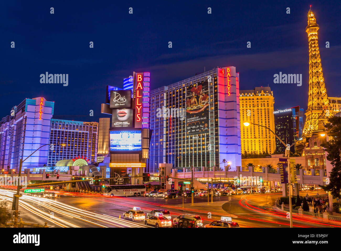 Luci al neon sulla Strip di Las Vegas con fari di automobile di lasciare striature chiare davanti a Parigi e Ballys, Las Vegas, Nevada, STATI UNITI D'AMERICA Foto Stock