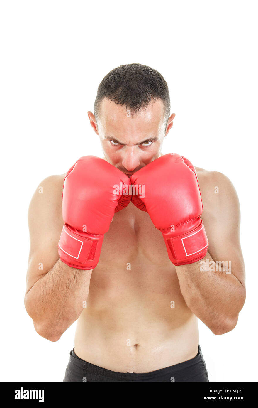 Grave uomo muscolare con collegato red guantoni da pugilato vicino al suo volto, pronti a combattere in un atteggiamento di combattimento Foto Stock