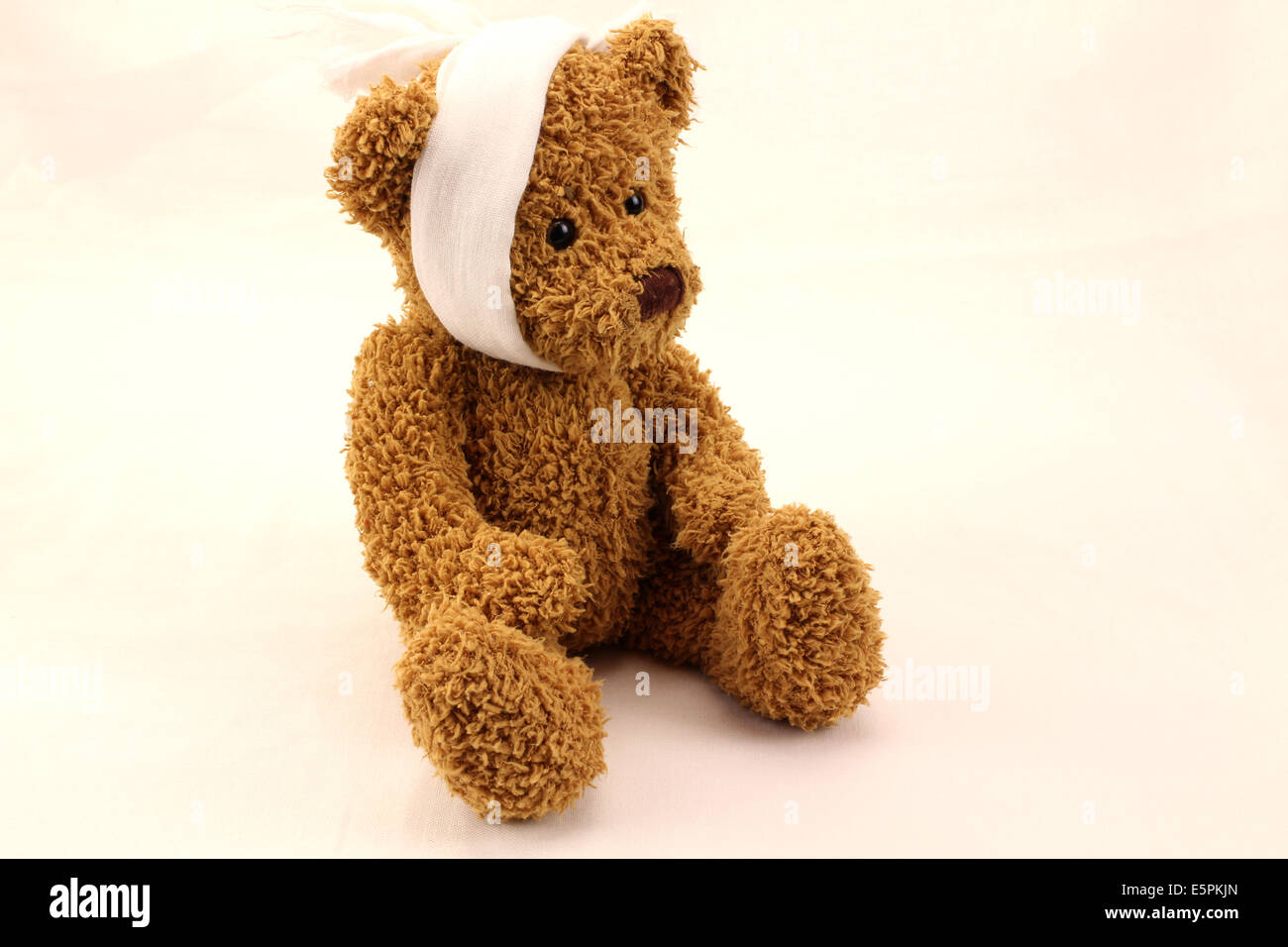 Simpatico orso giocattolo con il mal di denti benda su sfondo bianco Foto Stock