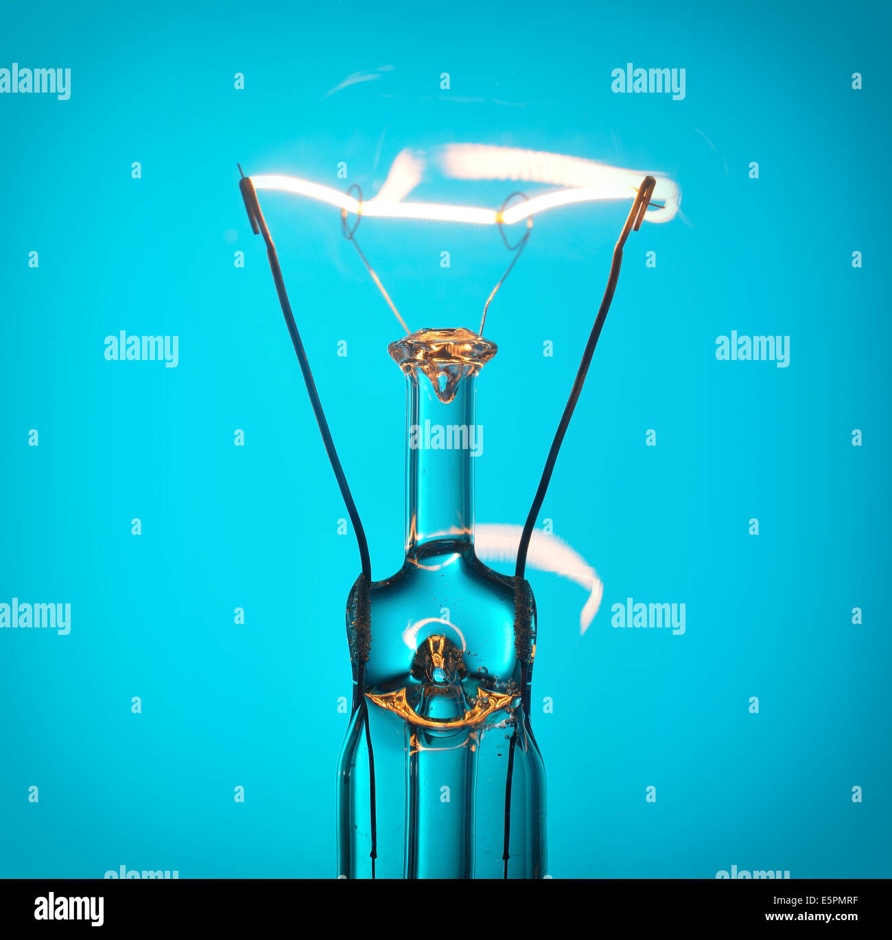 Close up incandescente lampadina luce su blu Foto Stock