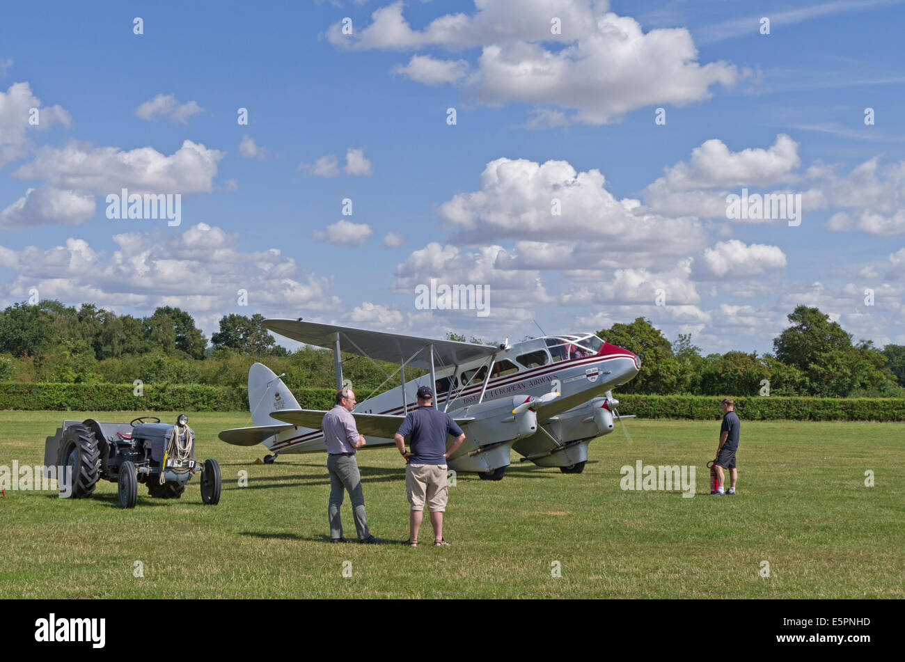 Una doppia elica aeromobili leggeri in attesa di prendere il via a Shuttleworth Airfield, Bedfordshire; tre osservatori maschi in attesa. Foto Stock
