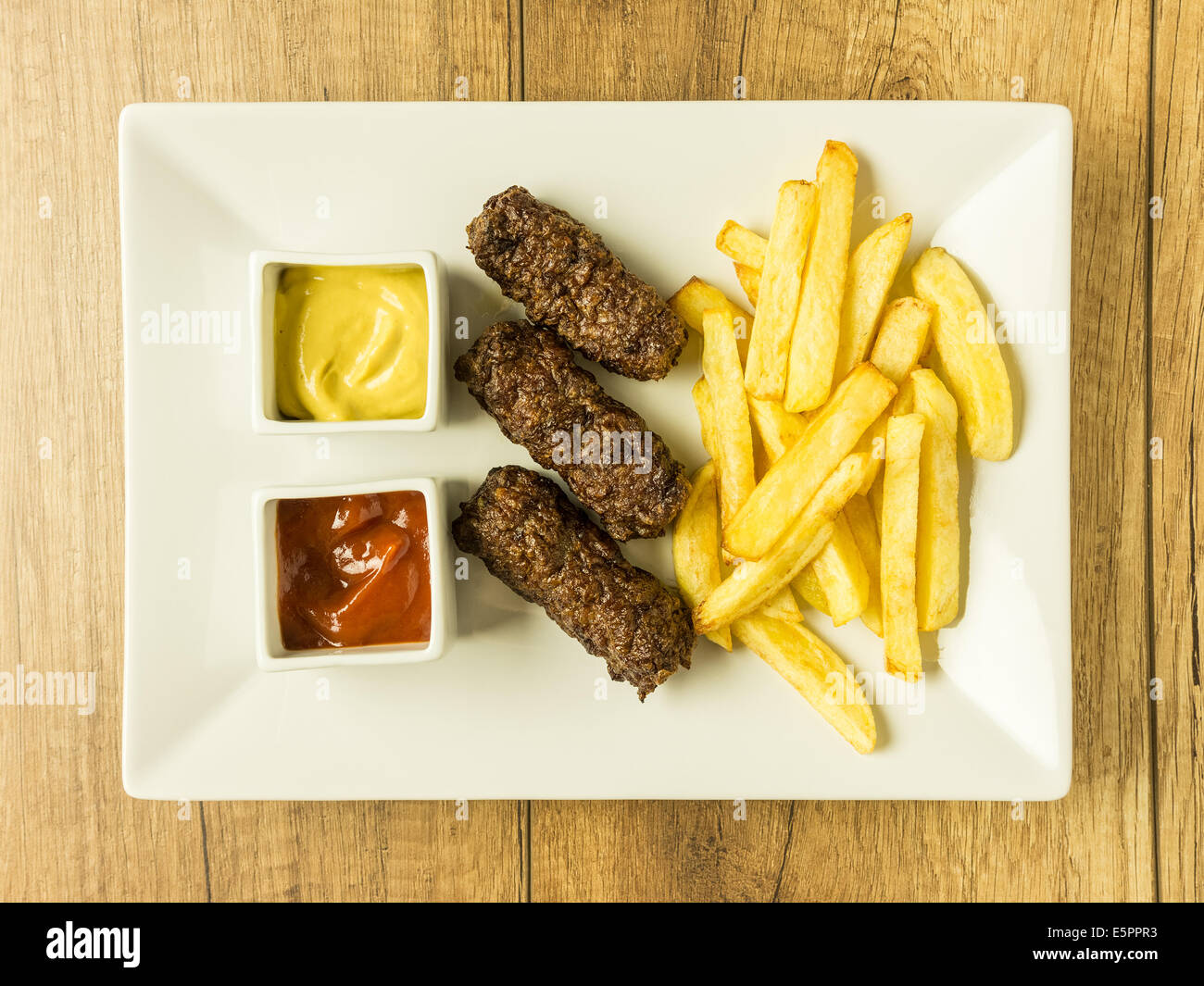 Tradizionale rumena polpette alimentare Mici e patate fritte con Ketchup e Senape Foto Stock