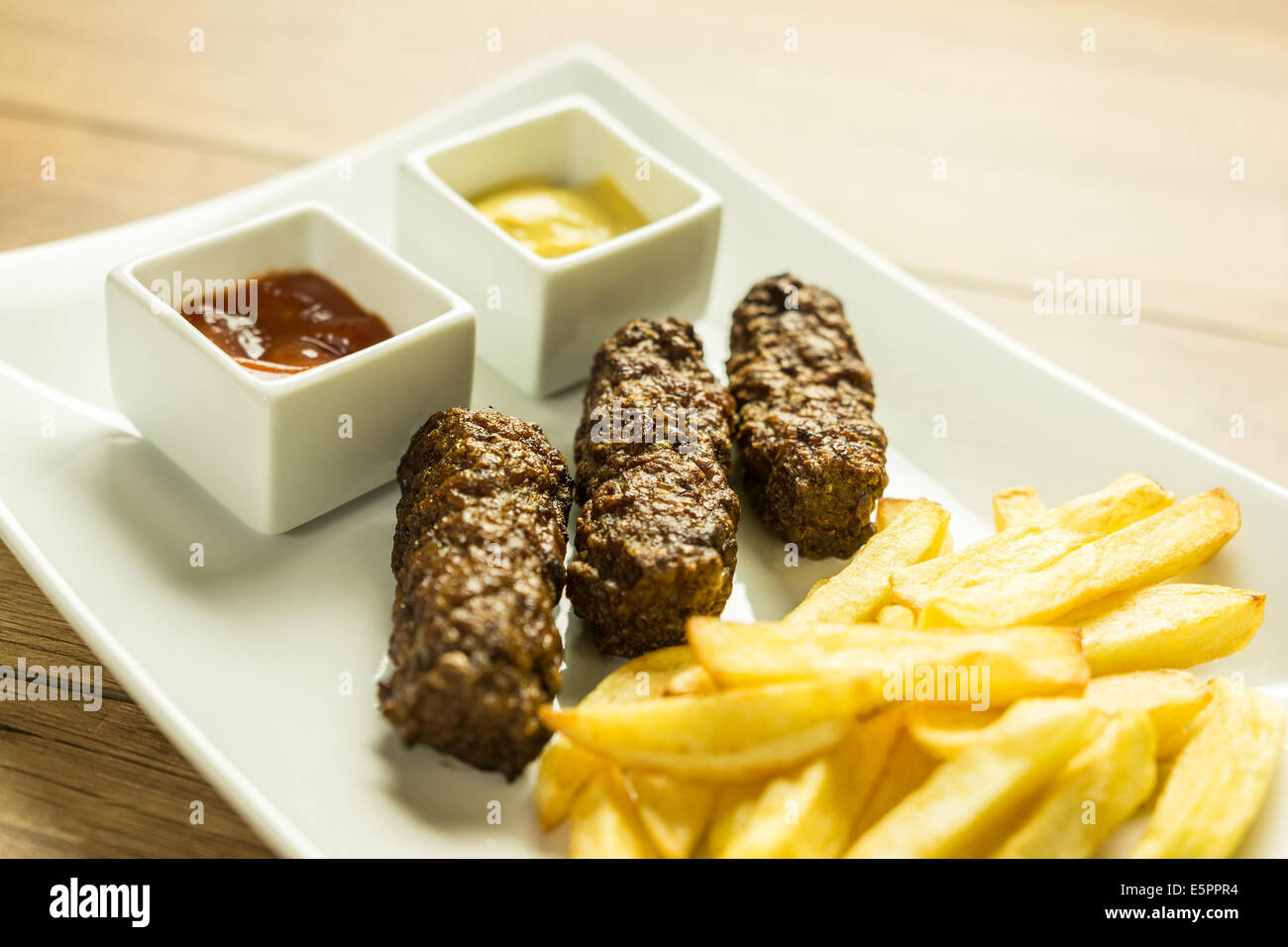 Tradizionale rumena polpette alimentare Mici e patate fritte con Ketchup e Senape Foto Stock