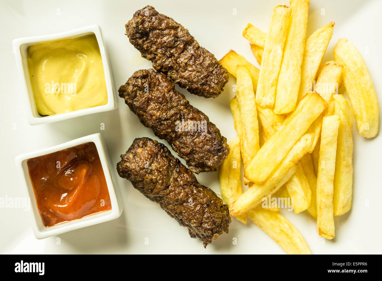 Tradizionale rumena Mici e patate fritte con Ketchup e Senape Close Up Foto Stock