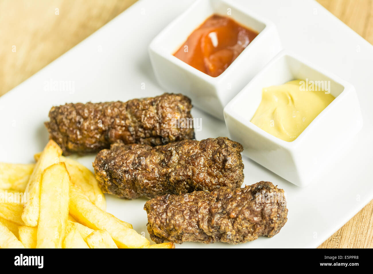 Tradizionale rumena Mici e patate fritte con Ketchup e Senape Close Up Foto Stock