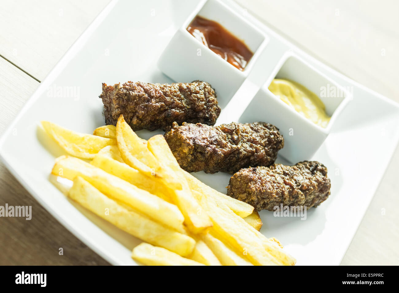 Tradizionale rumena Mici e patate fritte con Ketchup e Senape Close Up Foto Stock