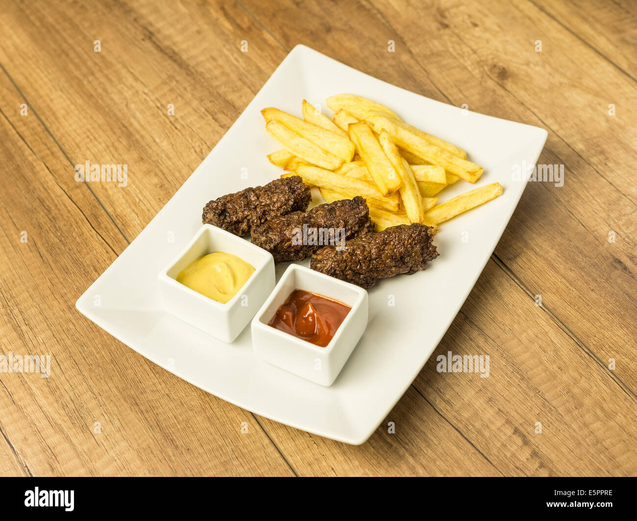 Tradizionale rumena polpette alimentare Mici e patate fritte con Ketchup e Senape Foto Stock