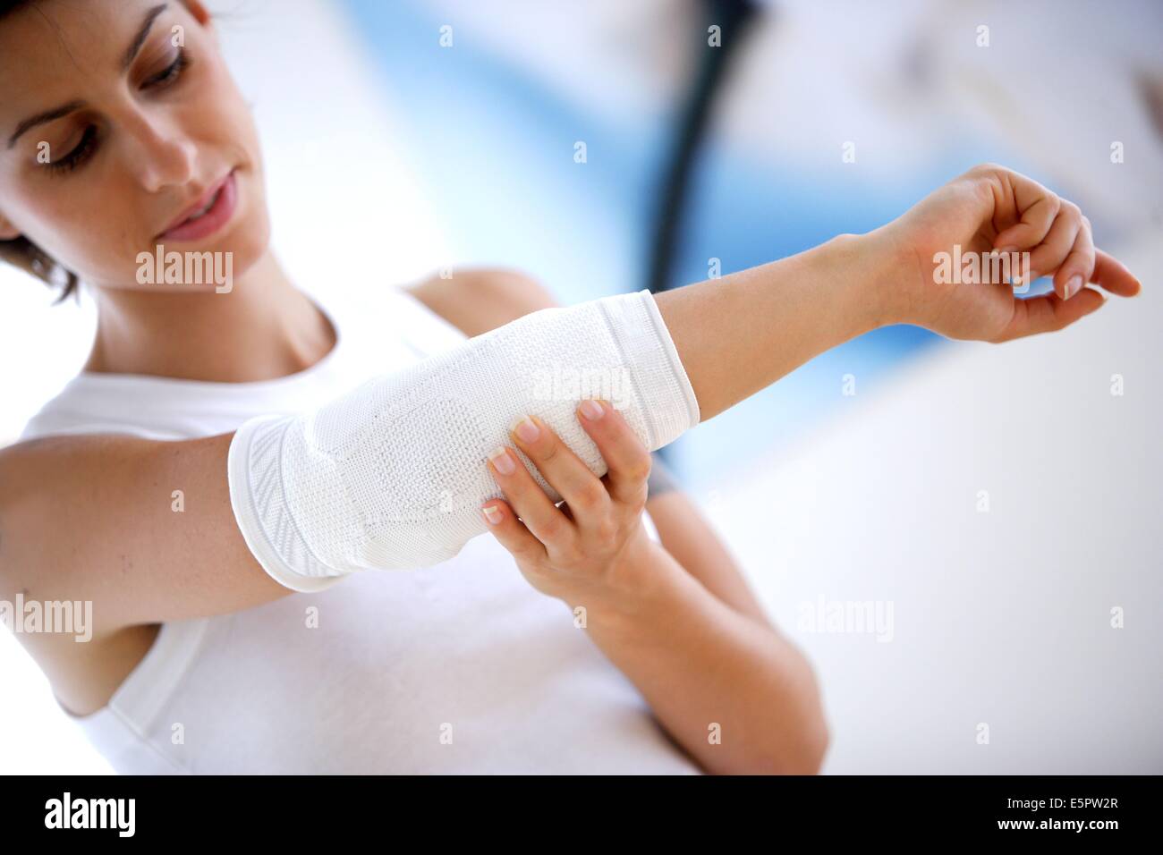 Donna che indossa un gomito titolare. Foto Stock