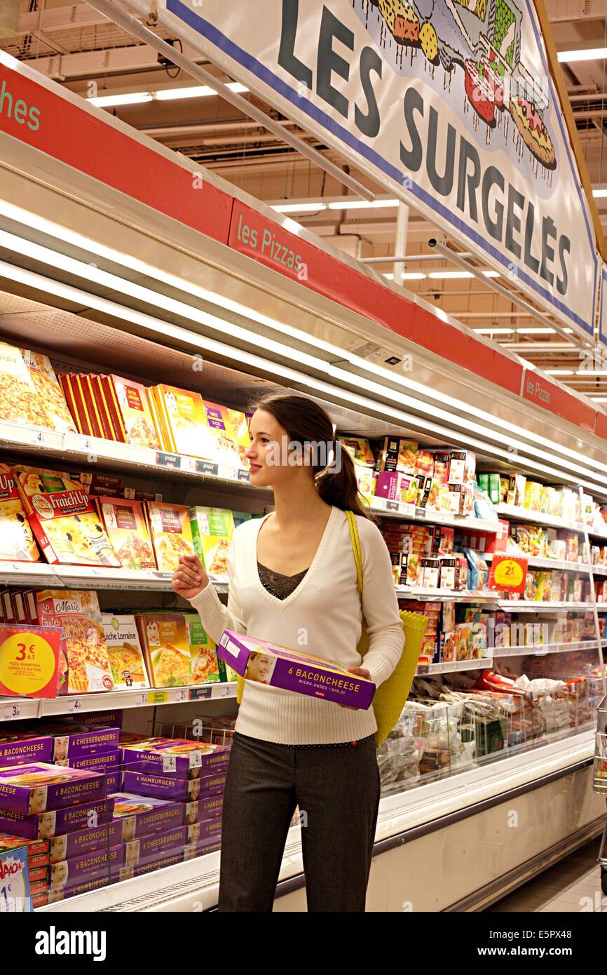 Donna shopping nei cibi congelati sezione nel supermercato. Foto Stock