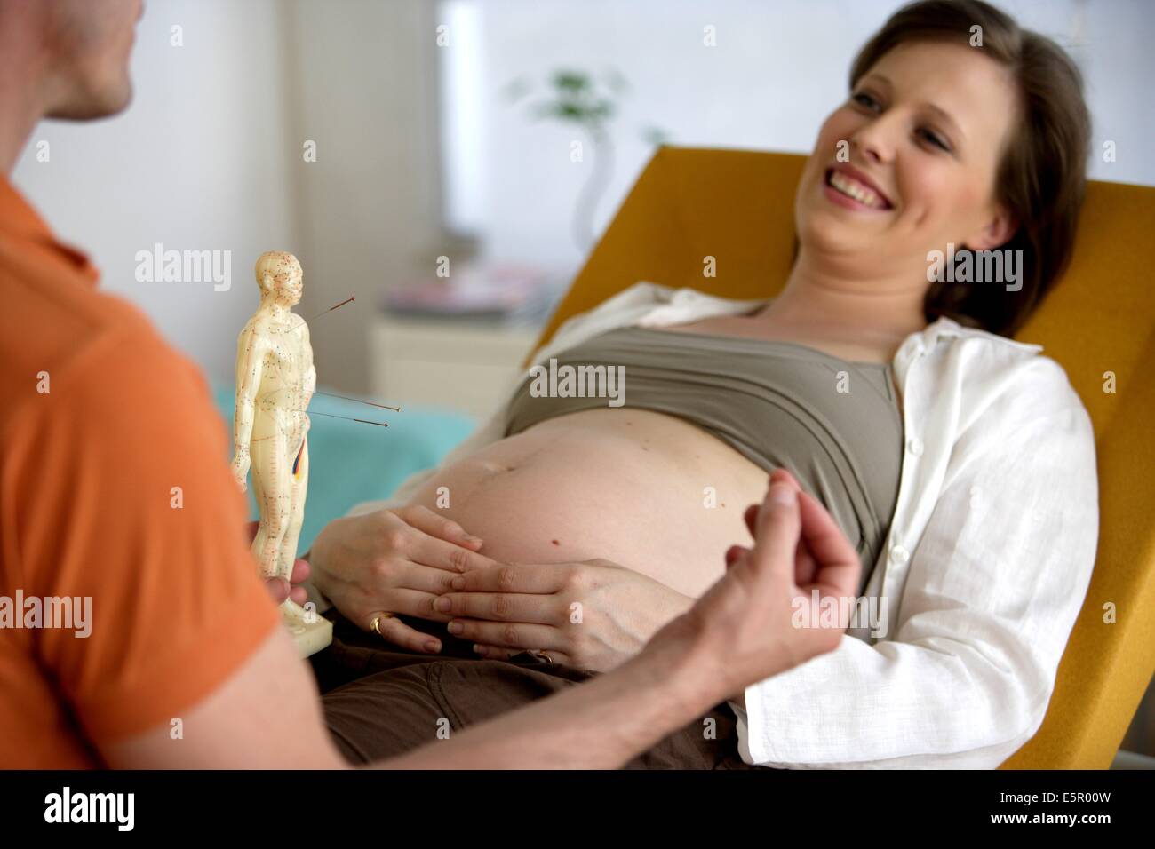 Donna incinta acupunture ricevente. Foto Stock