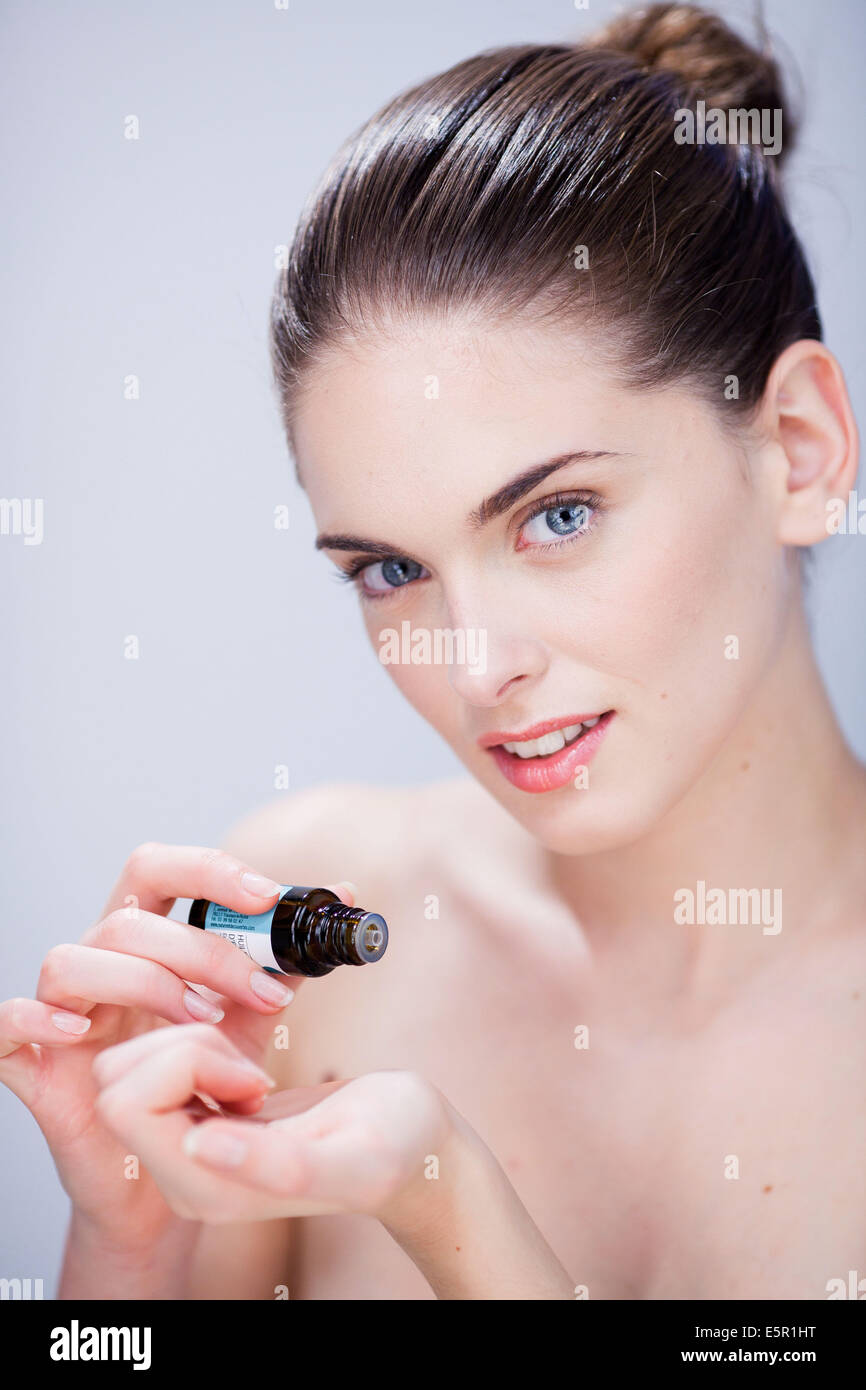 Donna l'applicazione di olio essenziale sulla sua pelle. Foto Stock