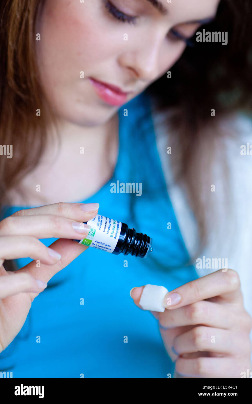 Donna di applicare olio essenziale sullo zucchero. Foto Stock
