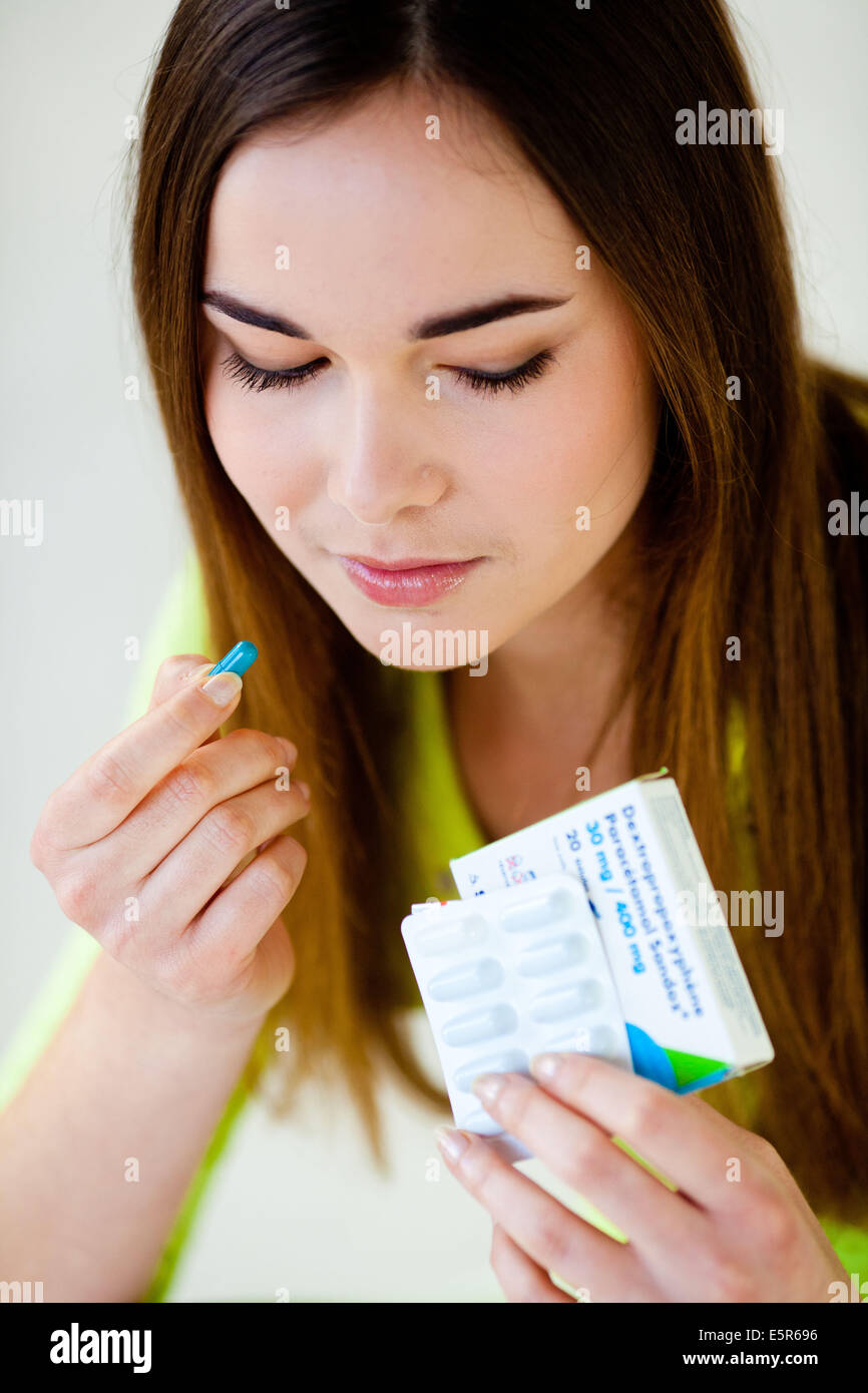 Giovane donna prendendo farmaco antalgica composta di paracetamolo e destropropossifene. Foto Stock