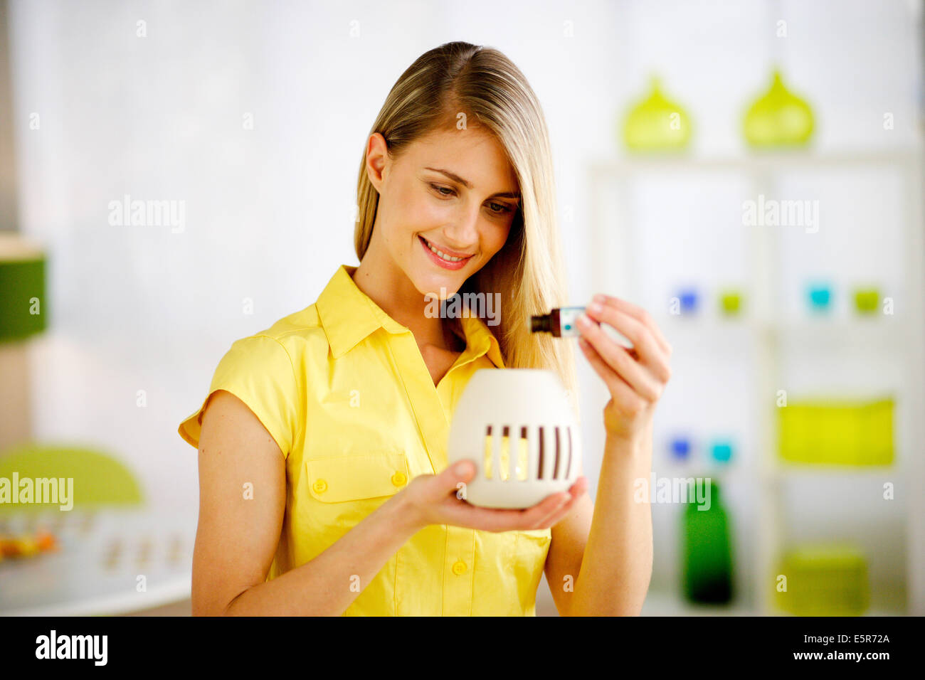 Donna che utilizza un olio essenziale diffusore. Foto Stock