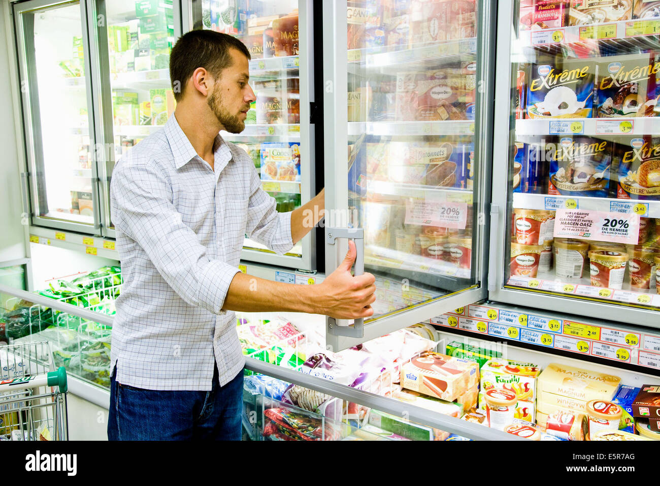 Uomo di shopping in alimenti congelati sezione nel supermercato. Foto Stock