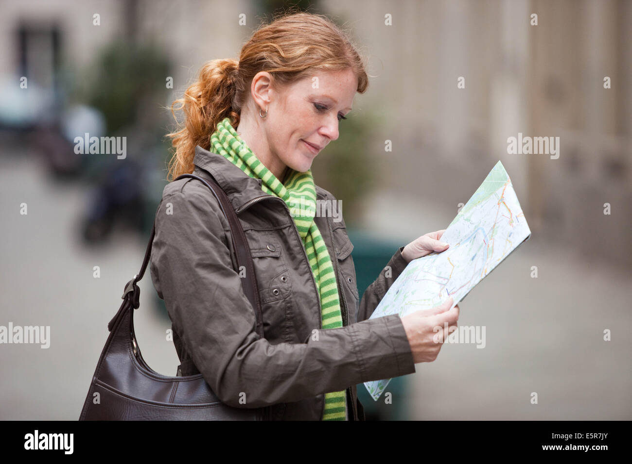Donna che utilizza mappa della città. Foto Stock