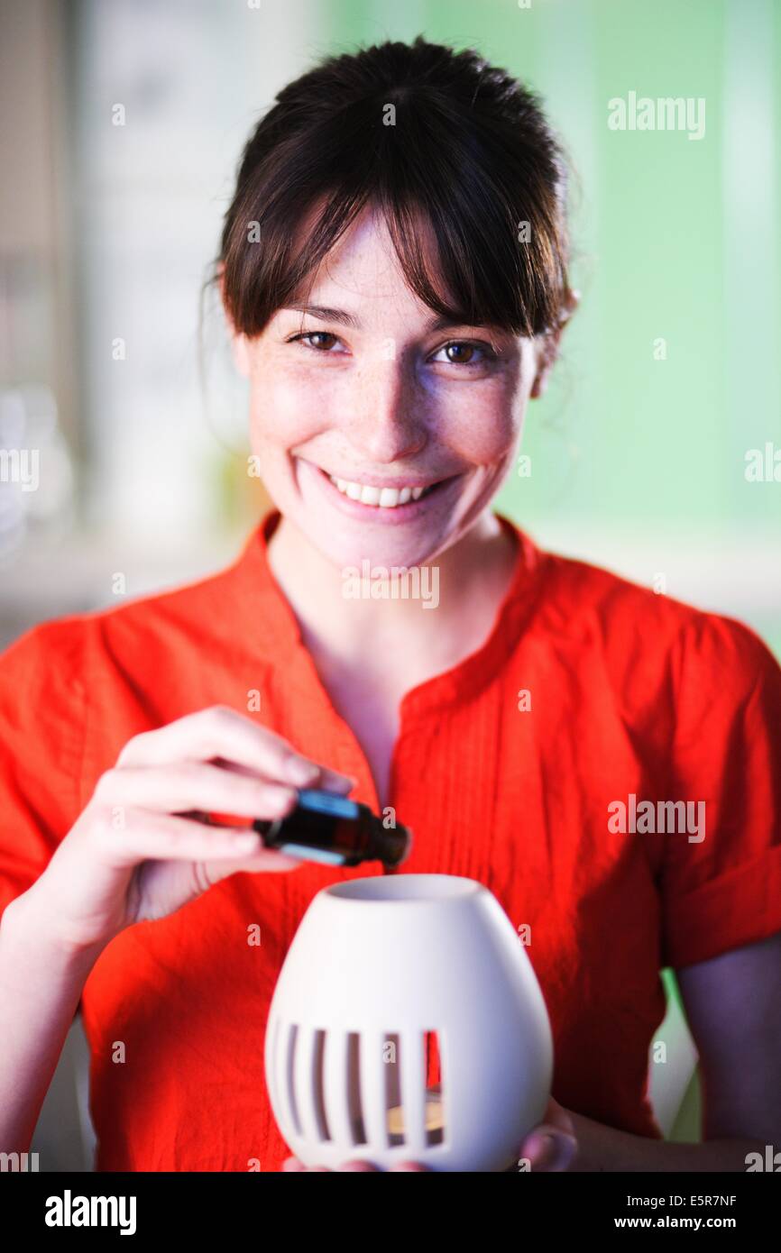 Donna che utilizza un olio essenziale diffusore. Foto Stock