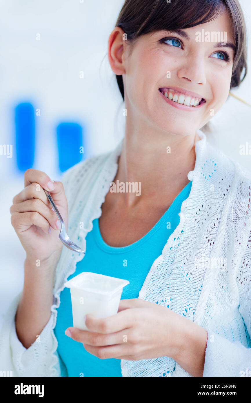 Donna di mangiare yogurt. Foto Stock