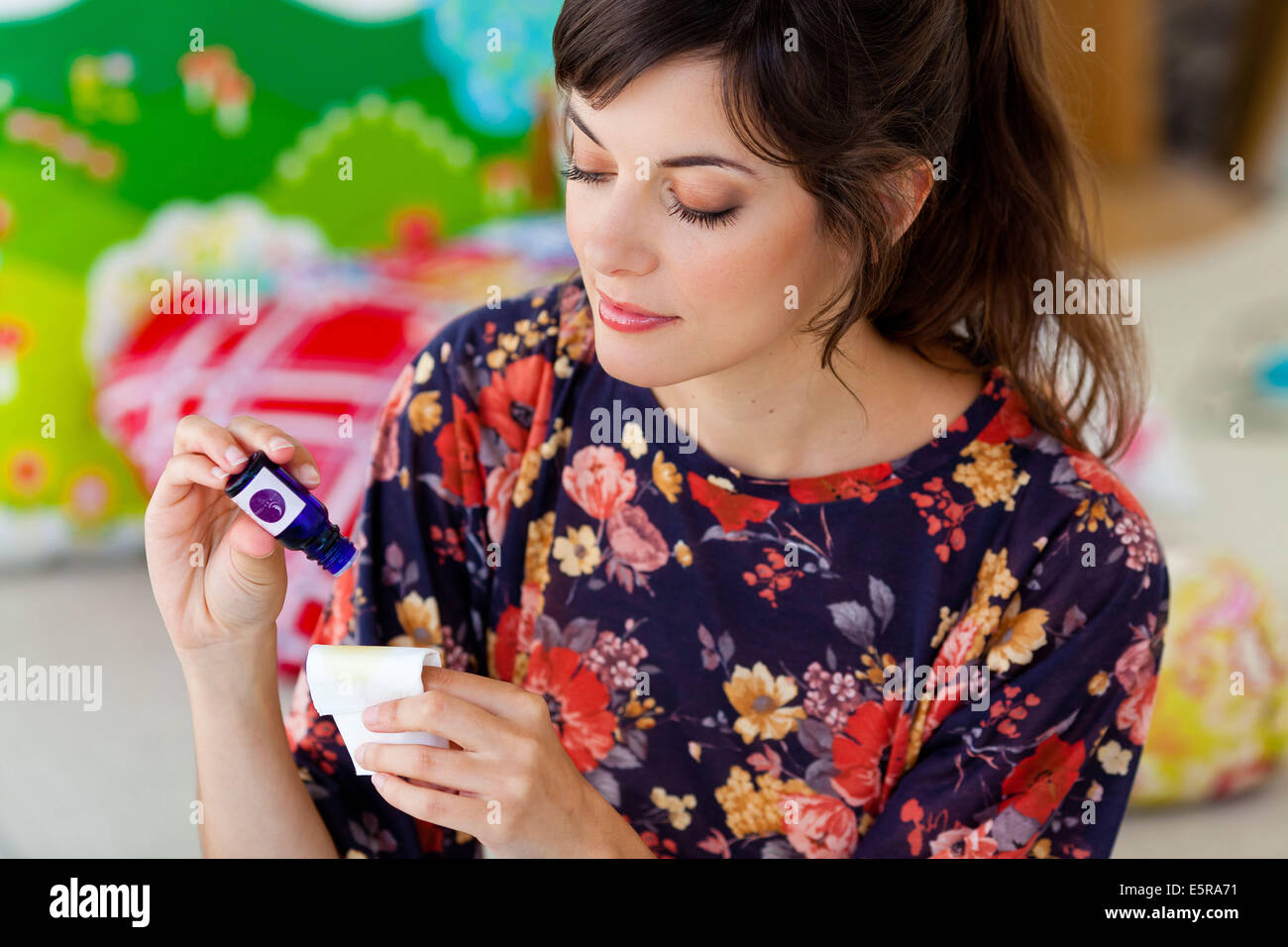 Donna l'applicazione di olio essenziale su un tessuto. Foto Stock