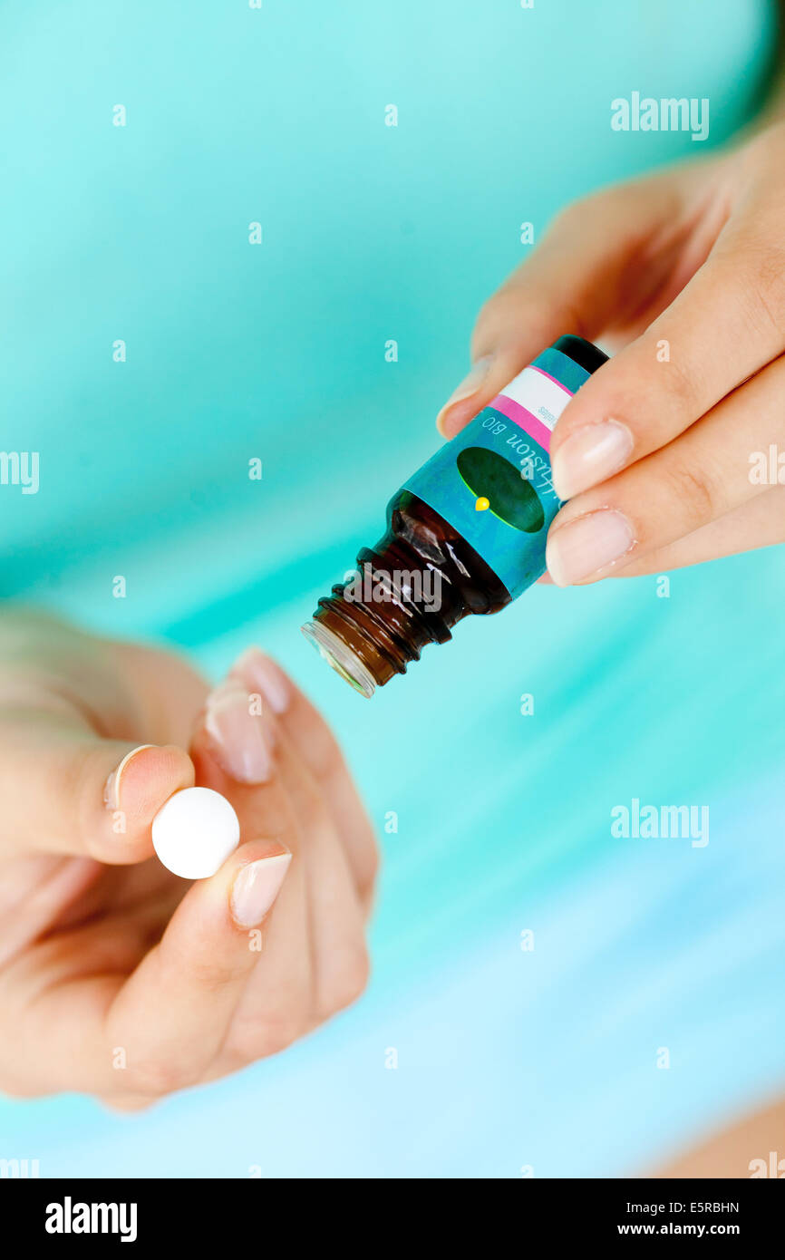 Donna l'applicazione di olio essenziale su una pillola di folle. Foto Stock