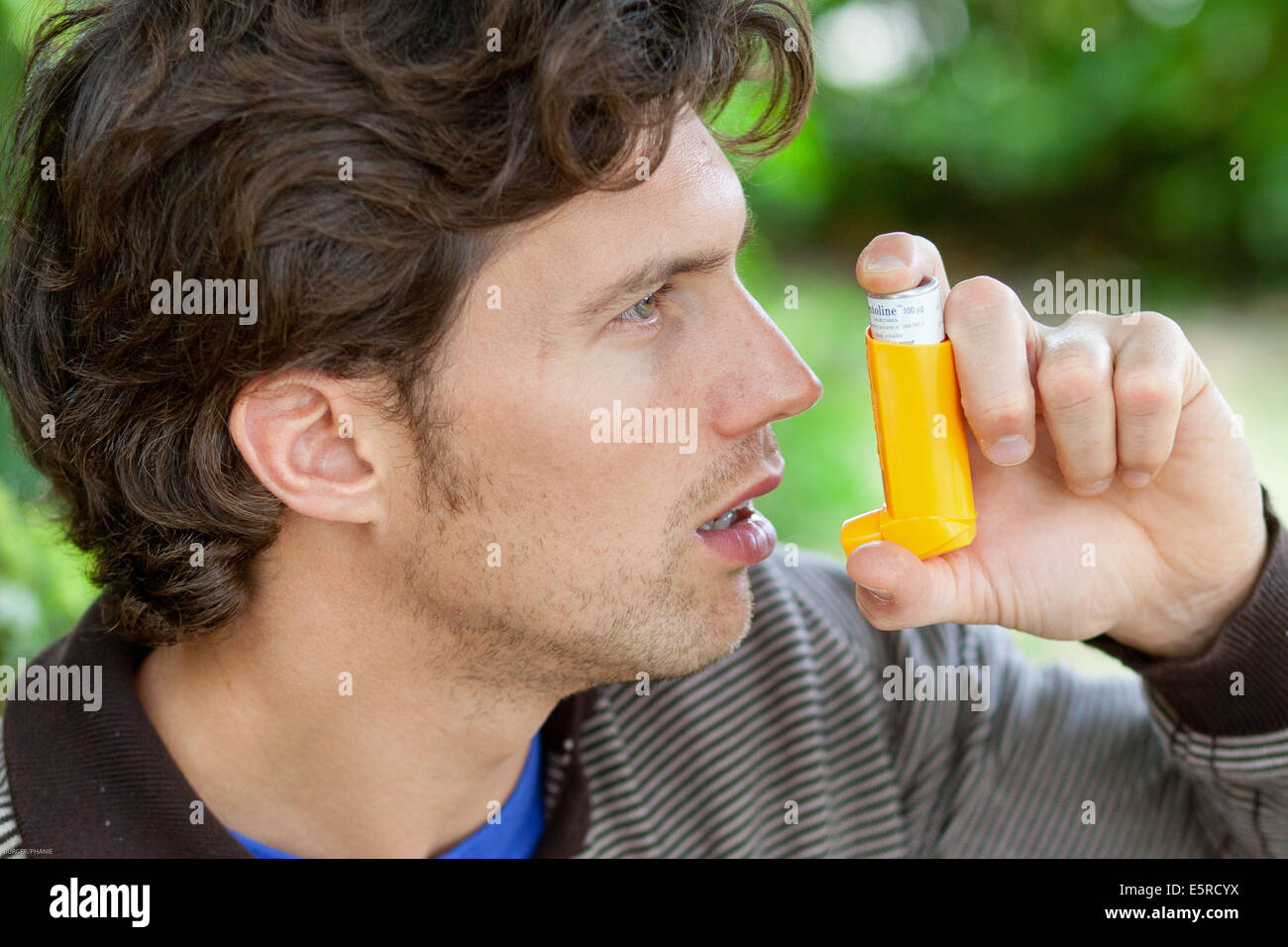 Uomo che utilizza un inalatore durante un attacco d' asma. Foto Stock