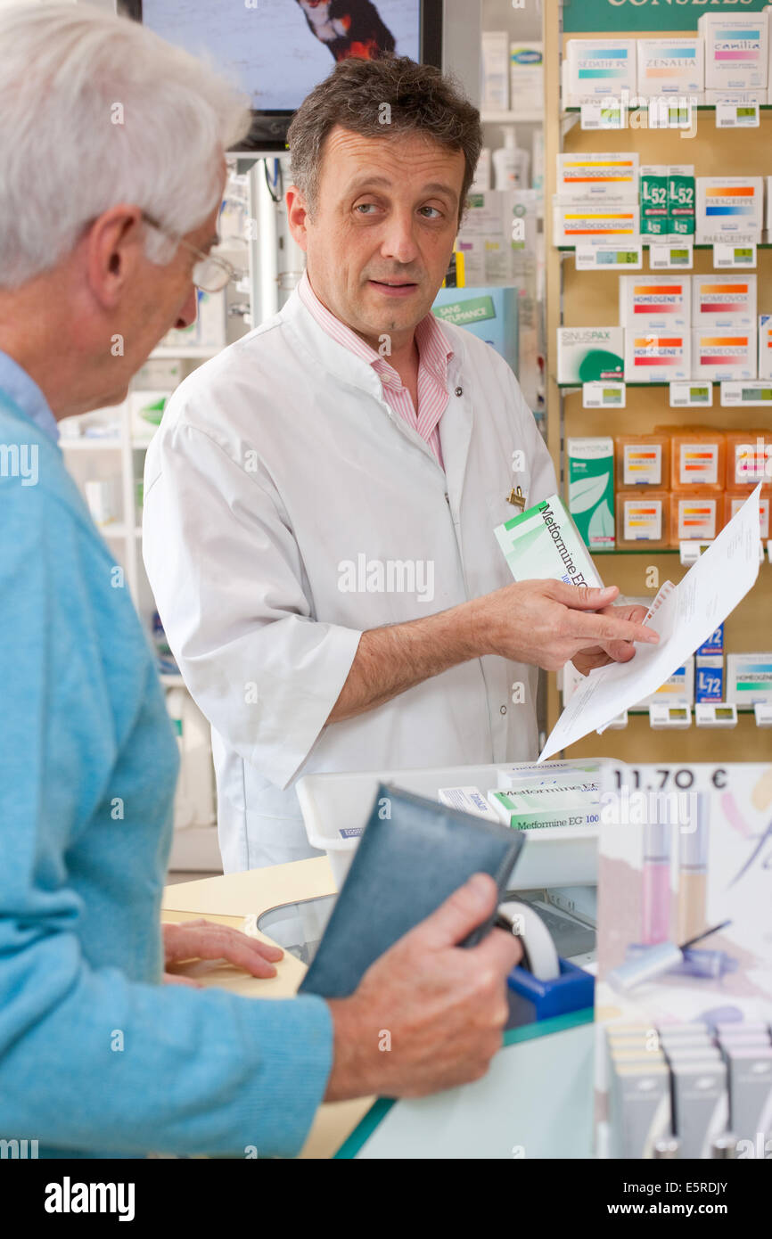 Il farmacista che mostra un cliente farmaci per il diabete. Foto Stock