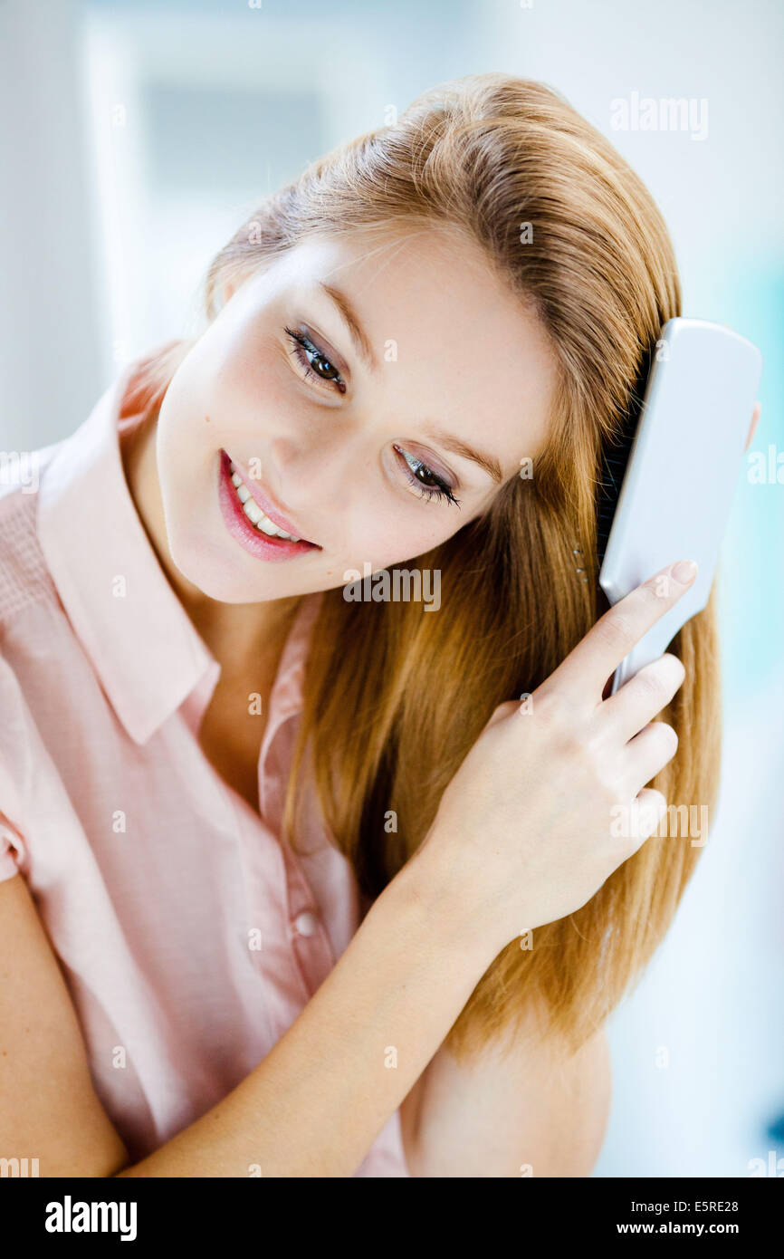 Donna spazzolare i capelli. Foto Stock