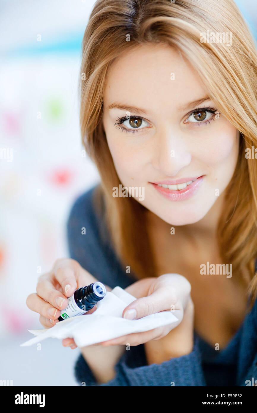 Donna l'applicazione di olio essenziale su un tessuto. Foto Stock