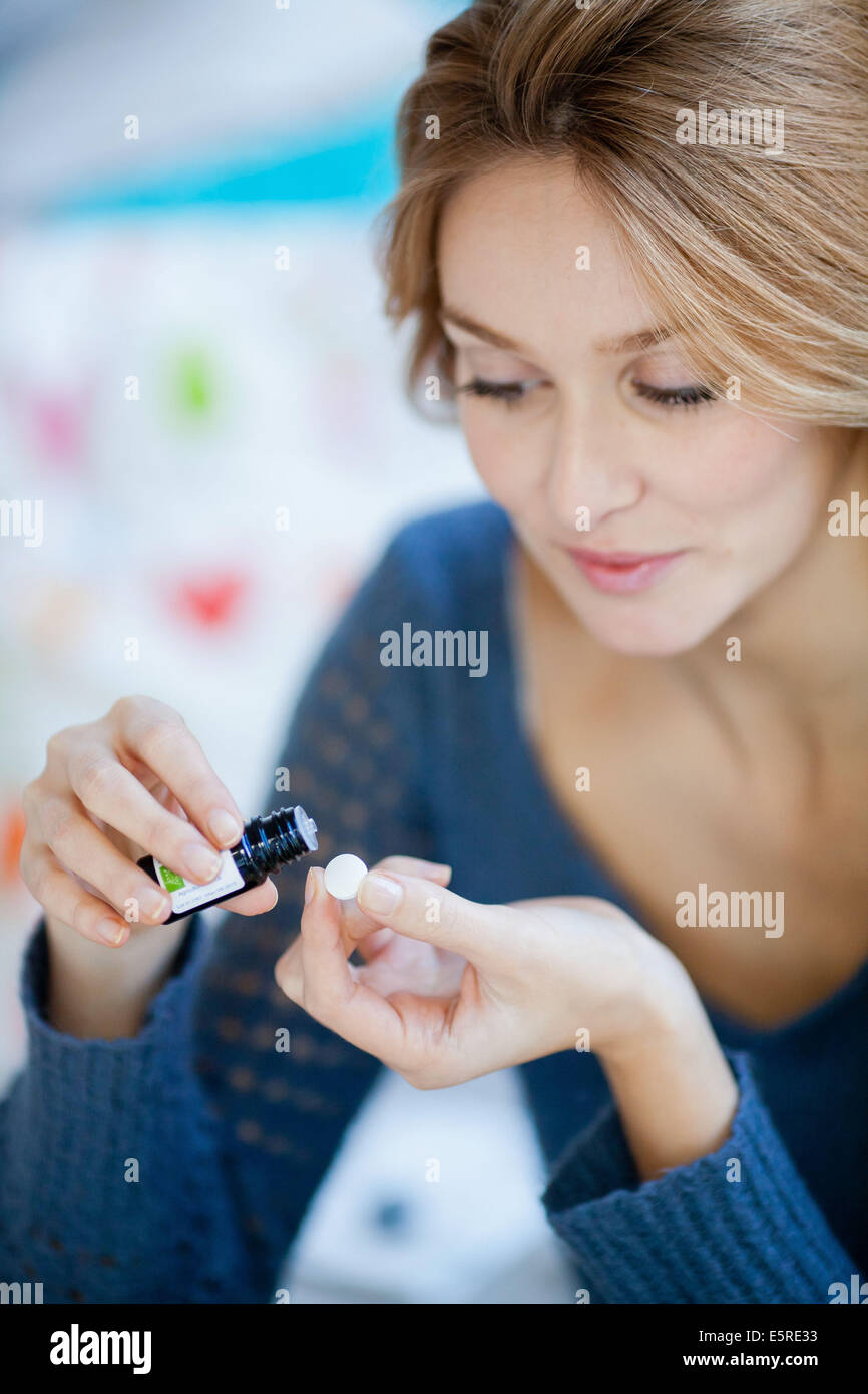 Donna l'applicazione di olio essenziale su una pillola di folle. Foto Stock