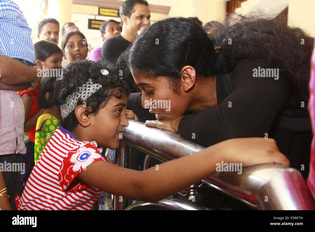 Kochi. 5 Ago, 2014. Uno dei 44 infermieri indiano evacuati da un paese lacerato dalla guerra Libia parla con sua figlia sul suo arrivo all aeroporto di Kochi in Kerala, India Il 5 agosto 2014. Credito: Stringer/Xinhua/Alamy Live News Foto Stock