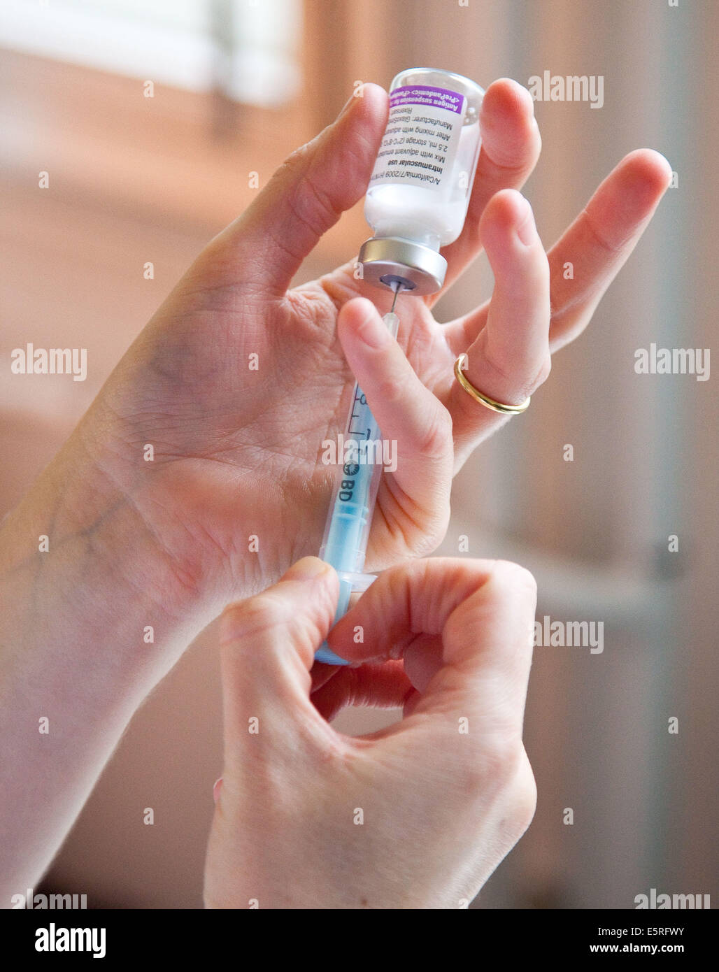 L'infermiera riempire una siringa con H1N1 (influenza aviaria) vaccino. Foto Stock
