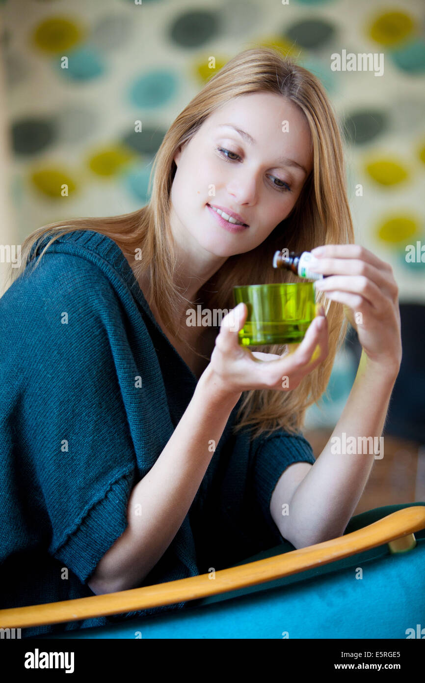 Donna che utilizza olio essenziale. Foto Stock