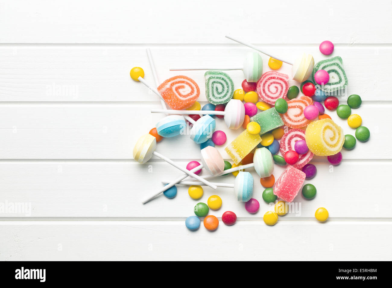 Vista dall'alto di caramelle colorate sul tavolo bianco Foto Stock