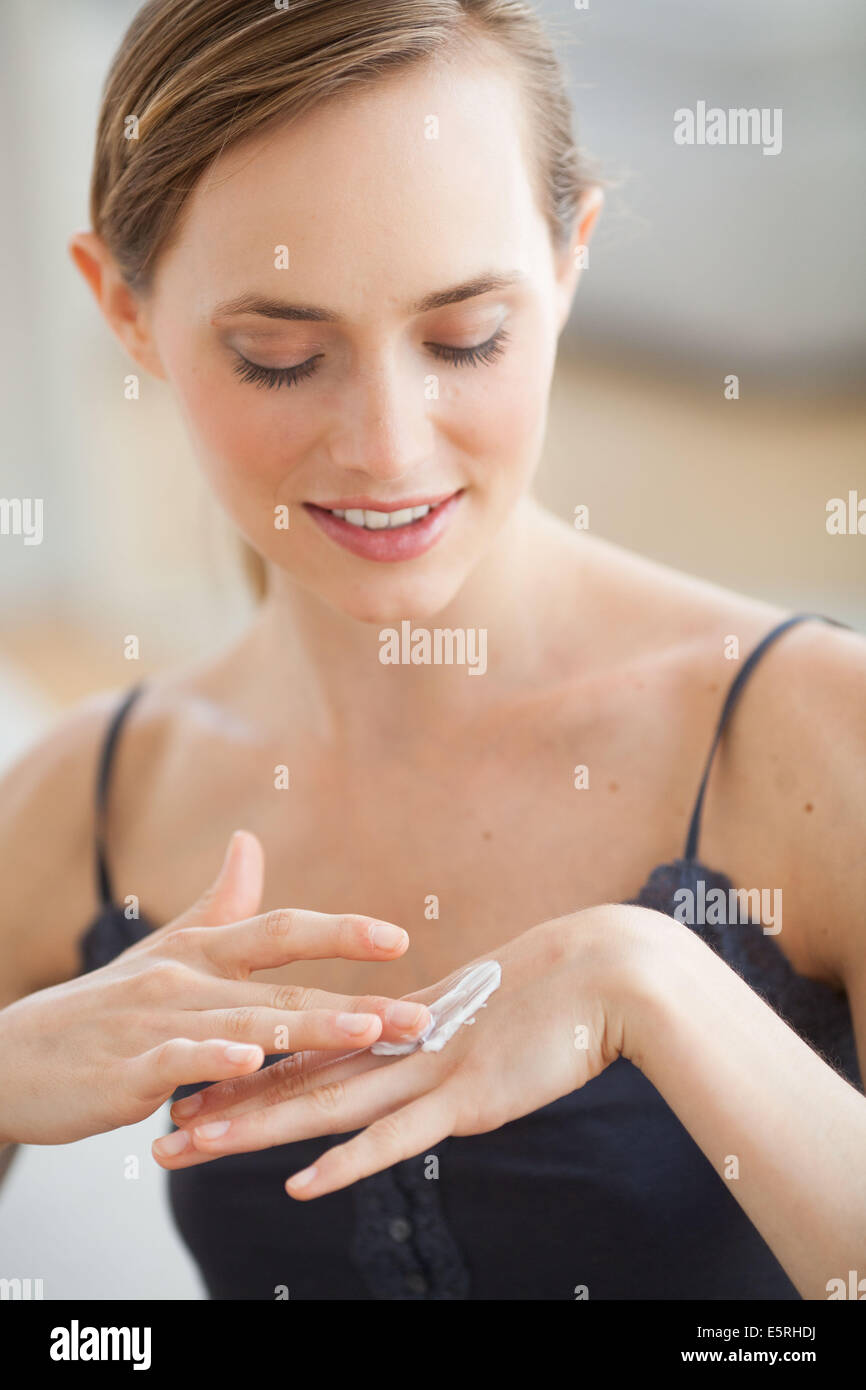 Donna l'applicazione di crema idratante sulle mani. Foto Stock